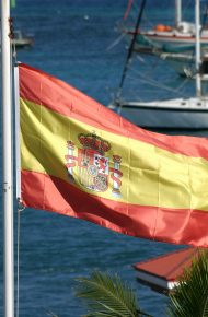 Una bandiera spagnola svolazzante su uno sfondo nautico